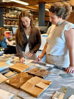 BCRA Intern Gabriella Pearson and Marissa Rosati, BCRA Interior Designer, study a variety of samples made of different colors, materials, and textures